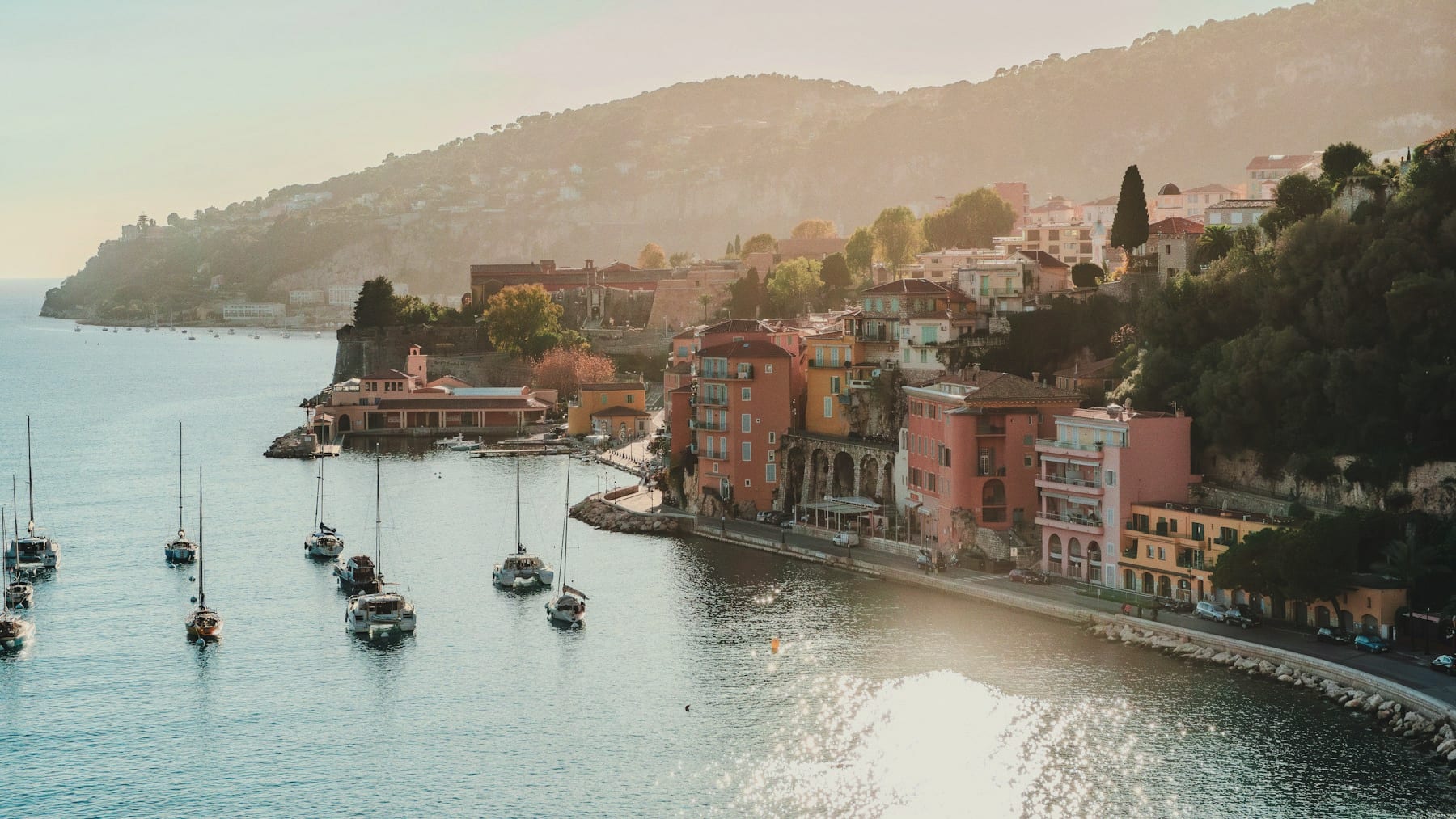 The pastel waterfront of Villefranche-sur-Mer on the Côte d'Azur, boats moored in golden afternoon light.